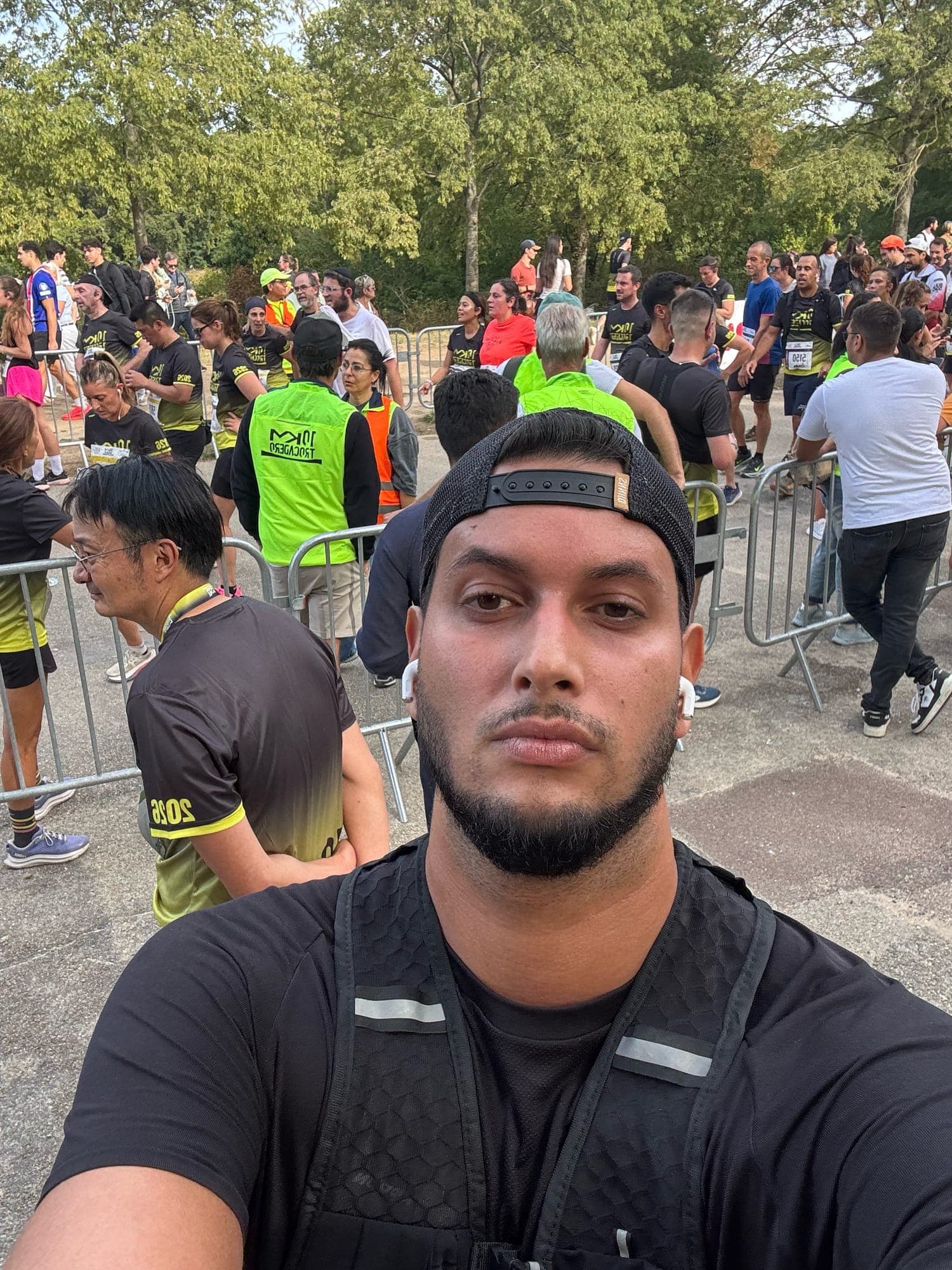 Selfie in a black running vest and backwards cap in a crowd of runners, some in vests marked 10 km Trocadéro.